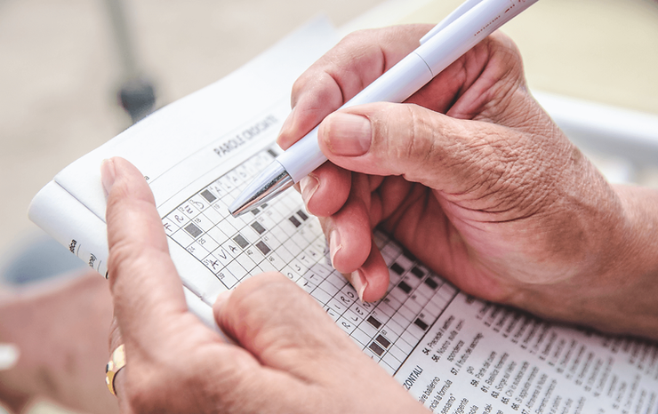Old woman doing crossword puzzle
